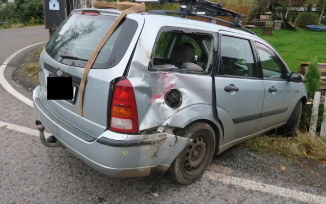 Řidič nedal přednost Tatře. Náraz odhodil auto na plot domu