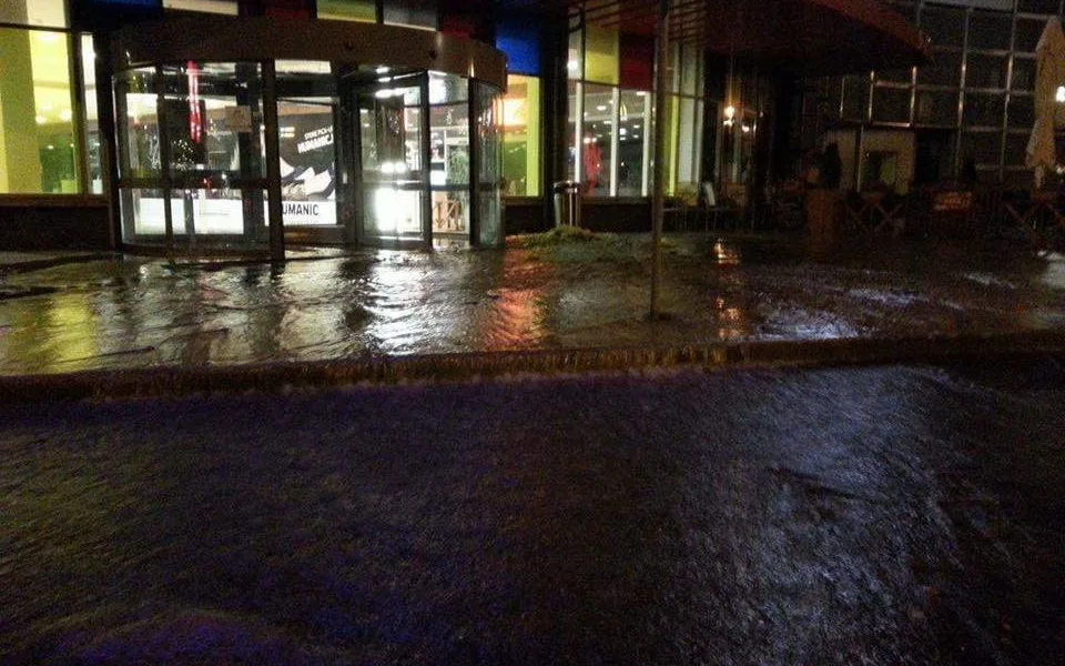 Voda z prasklého potrubí u OC Nisa zaplavila vchod i silnici u nákupního centra