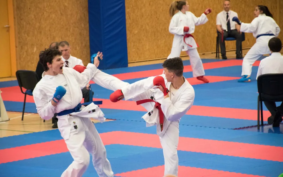 Fanda Chudoba (s červenou šerpou) získal v kumite na NP v Hradci stříbro.