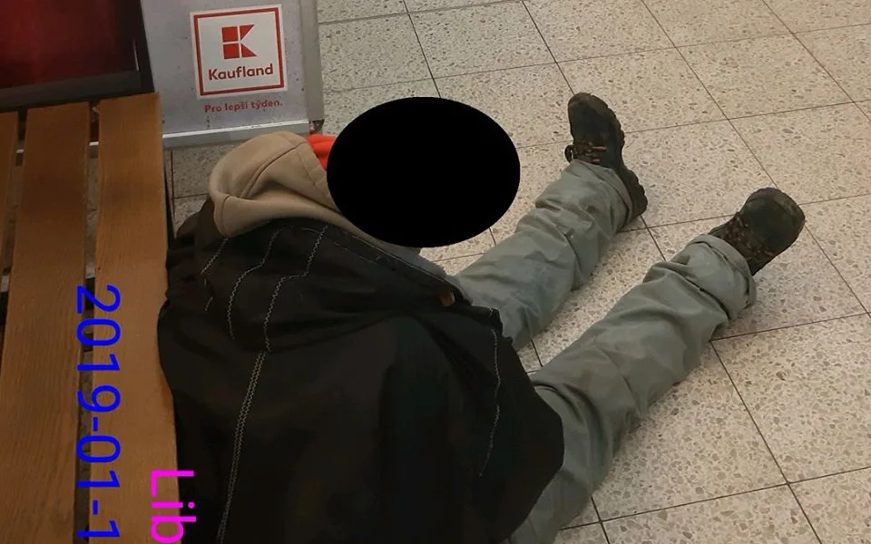 Bezdomovec usnul za pokladnami na zemi.