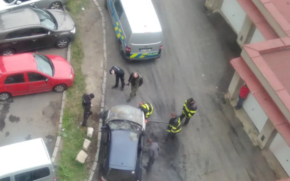 Hasiči s policisty zjišťují, proč auto začalo hořet.
