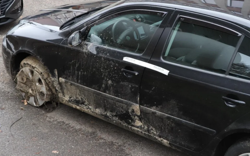 Auto s proraženými pneumatikami.