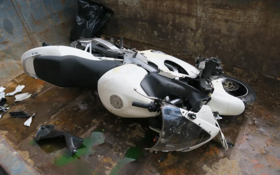 Rozbitá motorka po autonehodě.