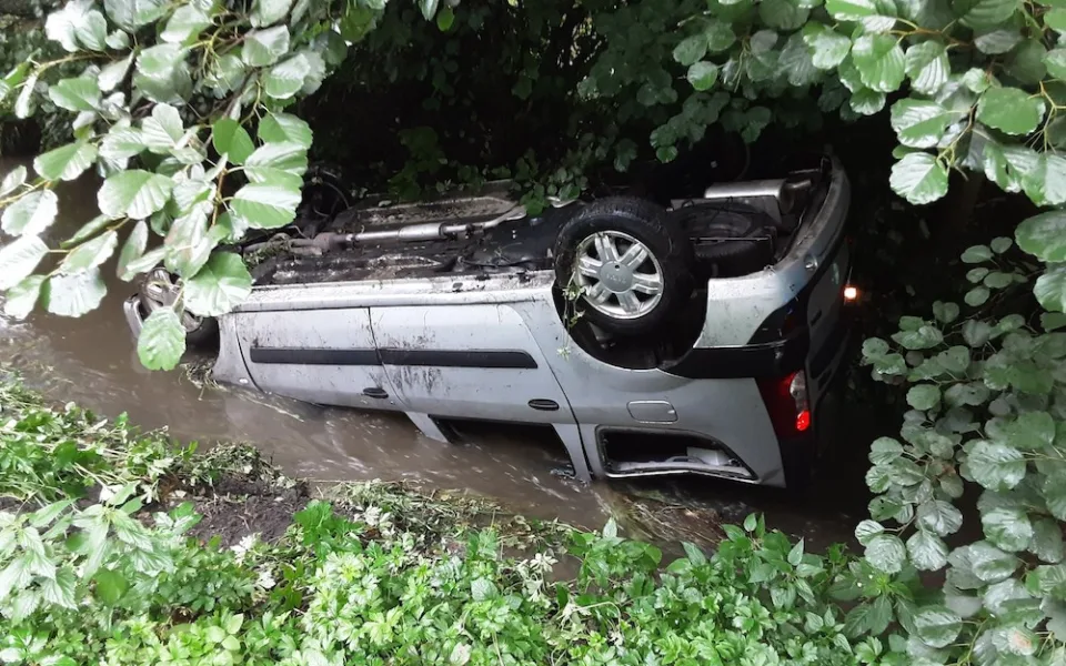 Na mokru se bouralo. Auto v Dubé se převrátilo do potoka