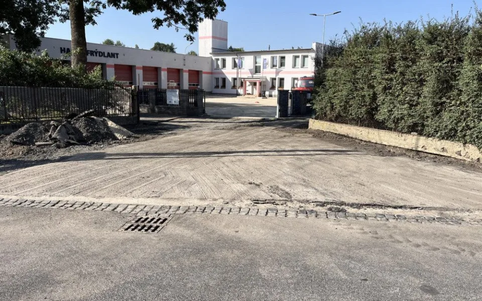 Oprava plochy před hasičskou zbrojnicí ve Frýdlantě finišuje pokládkou asfaltu.